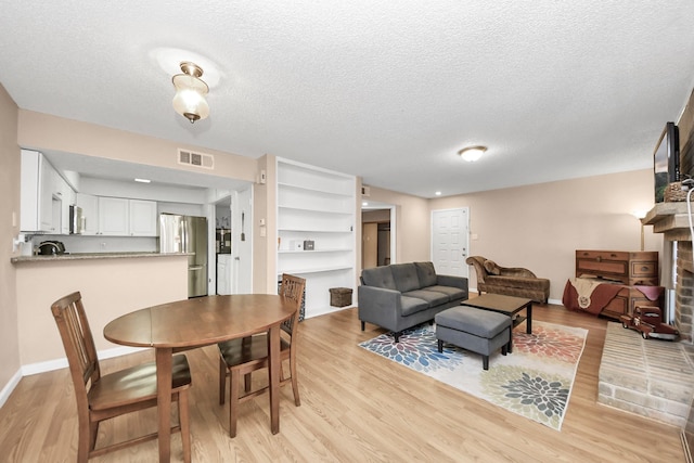 10555 Turtlewood Ct Unit 1510, Houston, TX 77072 - living area with a fireplace, light wood finished floors, visible vents, and baseboards