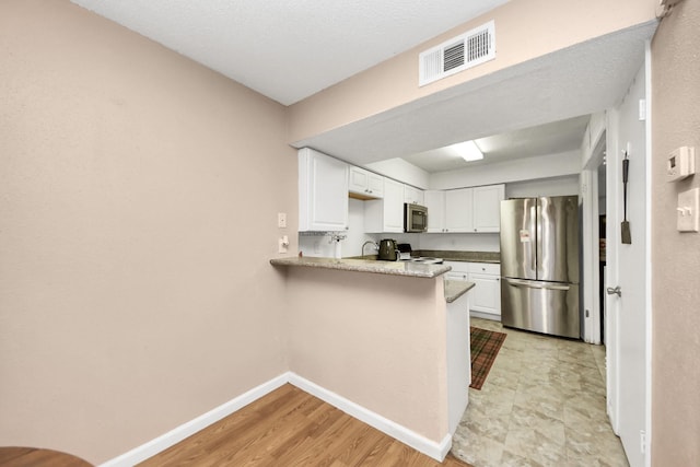 10555 Turtlewood Ct Unit 1510, Houston, TX 77072 - kitchen with appliances with stainless steel finishes, baseboards, white cabinetry, and visible vents