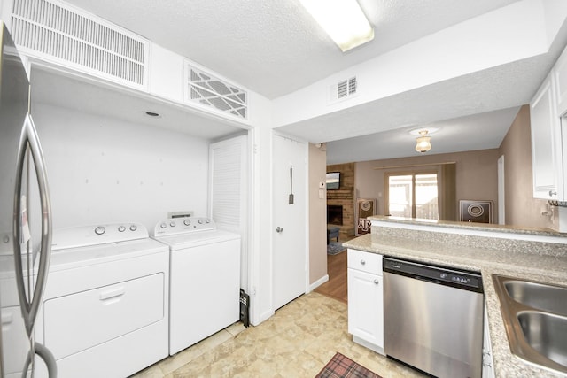 10555 Turtlewood Ct Unit 1510, Houston, TX 77072 - laundry room featuring separate washer and dryer, a fireplace, visible vents, laundry area, and a sink