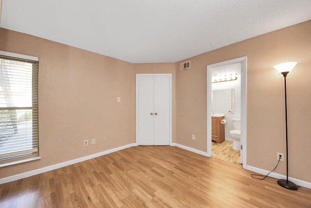 10555 Turtlewood Ct Unit 1510, Houston, TX 77072 - unfurnished bedroom with visible vents, baseboards, light wood-type flooring, and ensuite bath