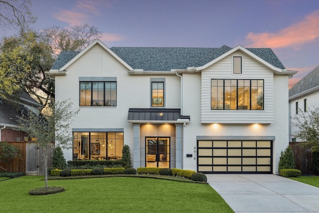 modern farmhouse style home featuring driveway, a standing seam roof, a yard, a shingled roof, and metal roof