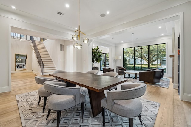 dining room featuring stairway, plenty of natural light, and light wood-style floors