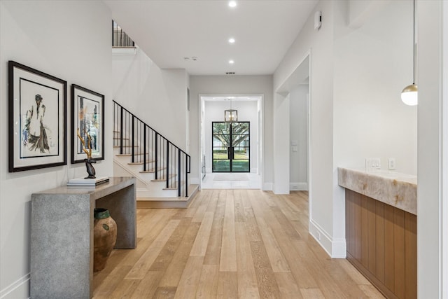 entryway with stairway, recessed lighting, light wood-type flooring, and baseboards