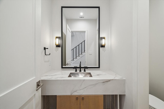 half bathroom featuring toilet and vanity