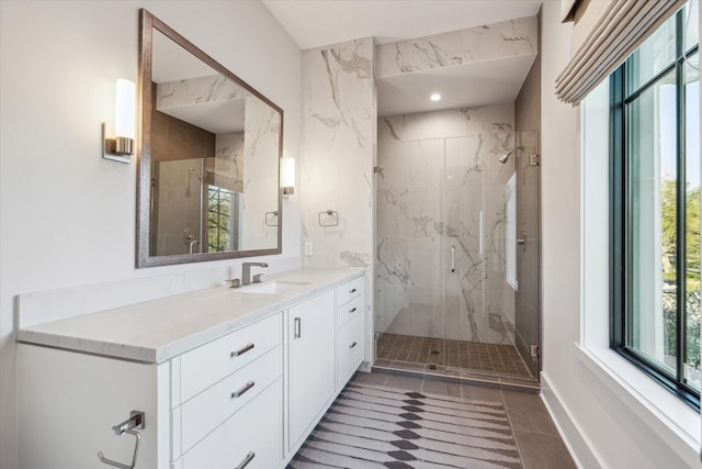 bathroom featuring a marble finish shower, tile patterned flooring, recessed lighting, and vanity