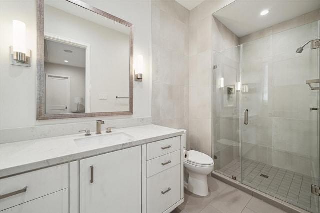 full bath featuring tile patterned flooring, a shower stall, toilet, and vanity