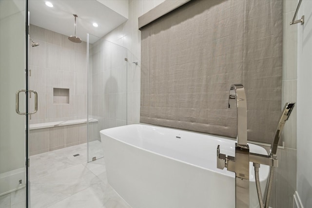 full bath with a shower stall, recessed lighting, a soaking tub, marble finish floor, and tile walls