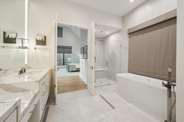 full bathroom with vanity, a soaking tub, a stall shower, and ensuite bath