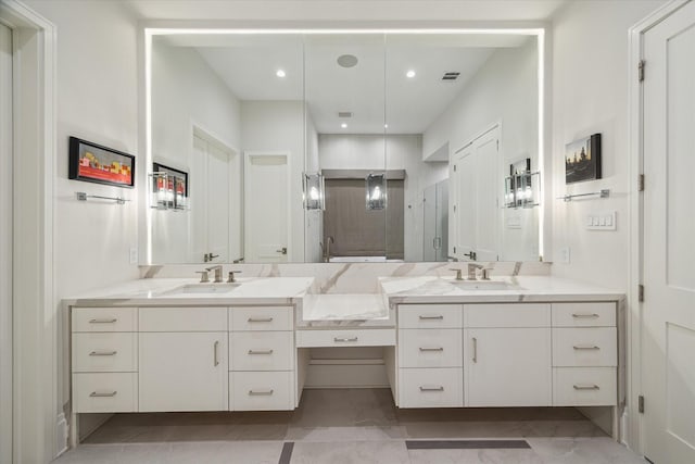 bathroom with double vanity, a shower stall, and a sink