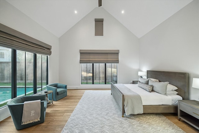 bedroom with wood finished floors and high vaulted ceiling