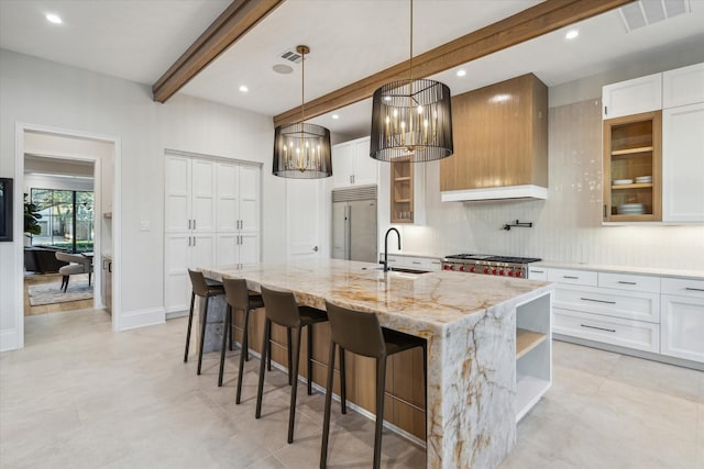 kitchen with visible vents, a sink, stainless steel built in refrigerator, beamed ceiling, and open shelves