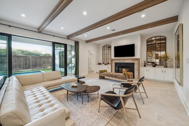 living area with beam ceiling, recessed lighting, a warm lit fireplace, and baseboards