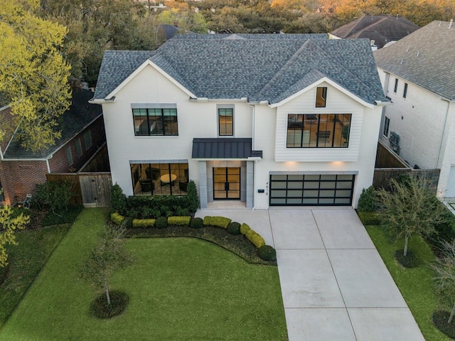 view of front facade with driveway, a standing seam roof, an attached garage, a shingled roof, and metal roof