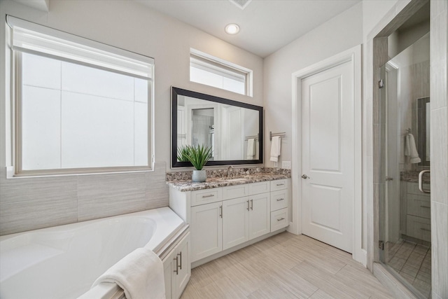 bathroom with vanity, a bath, and a stall shower