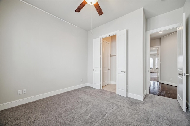 unfurnished bedroom with carpet flooring, baseboards, and ceiling fan