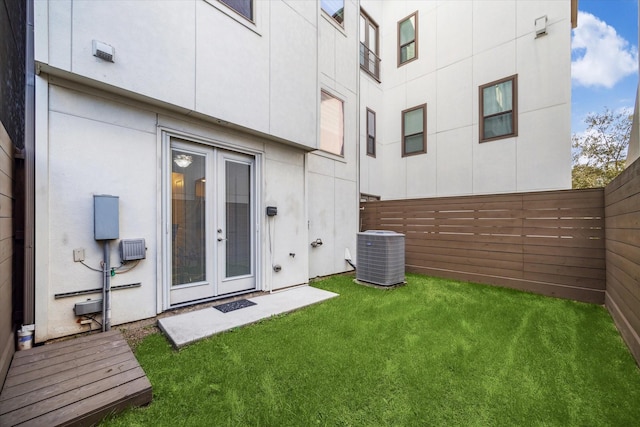 back of property featuring a lawn, cooling unit, french doors, and fence