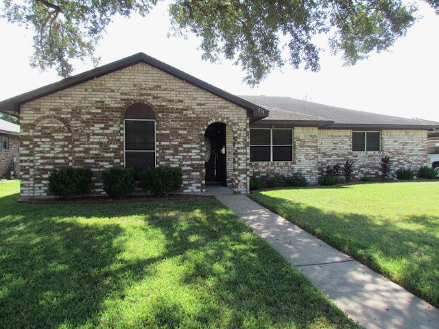 ranch-style house featuring brick siding and a front yard