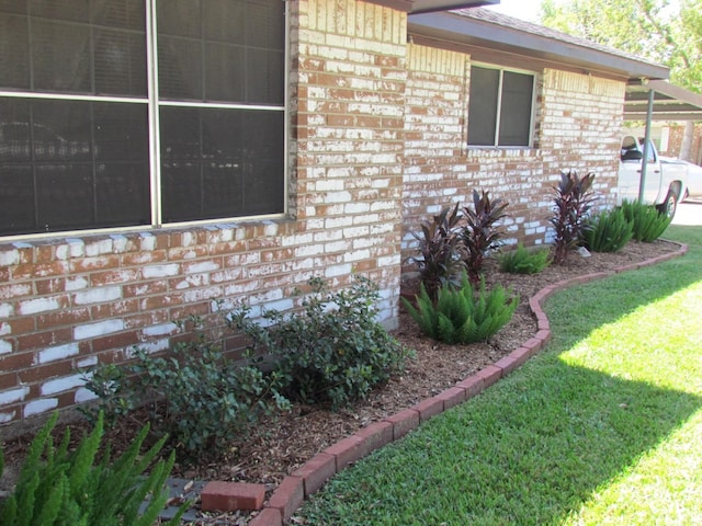 view of property exterior with brick siding and a yard