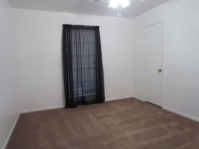 spare room with carpet flooring, a ceiling fan, and baseboards