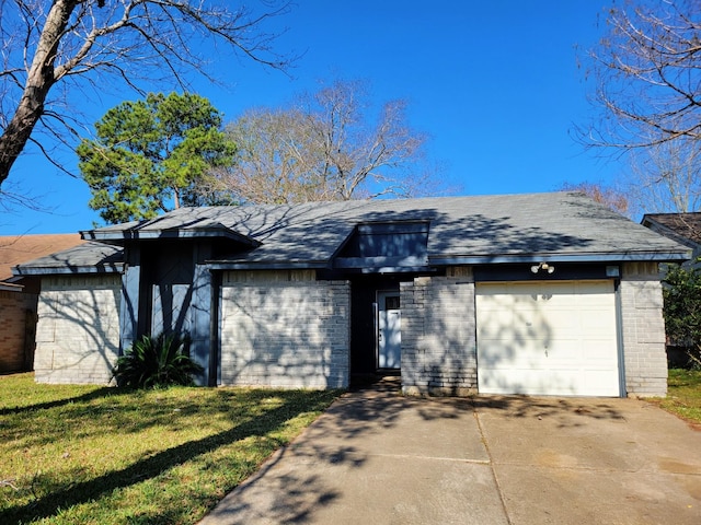 mid-century home with a front lawn, a garage, brick siding, and driveway