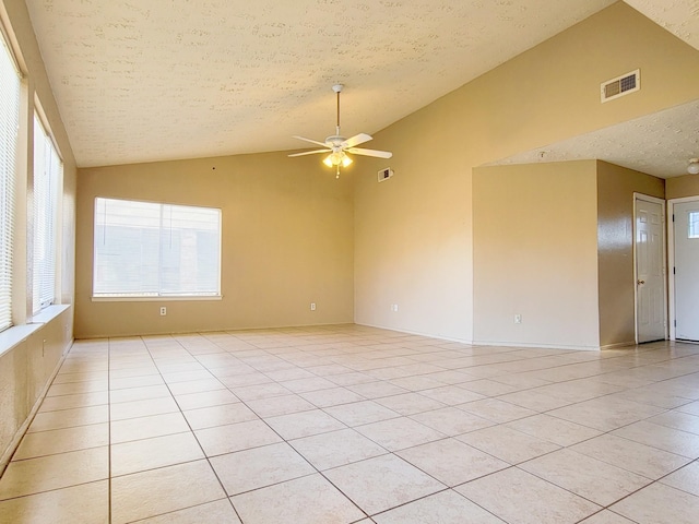 unfurnished room with light tile patterned floors, a ceiling fan, visible vents, vaulted ceiling, and a textured ceiling