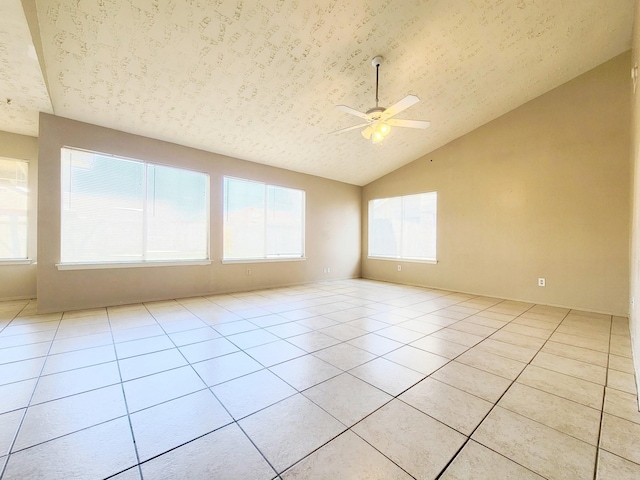 unfurnished room featuring lofted ceiling, light tile patterned floors, a ceiling fan, and a textured ceiling