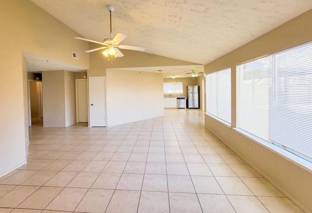 spare room with light tile patterned floors, visible vents, lofted ceiling, and ceiling fan