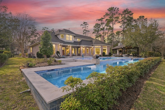 back of house with an outdoor pool, a gazebo, a patio area, and a lawn