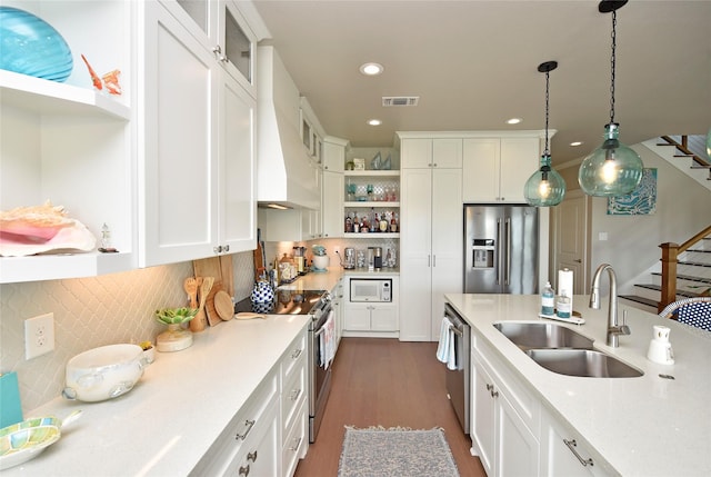 kitchen with open shelves, decorative light fixtures, stainless steel appliances, white cabinetry, and a sink