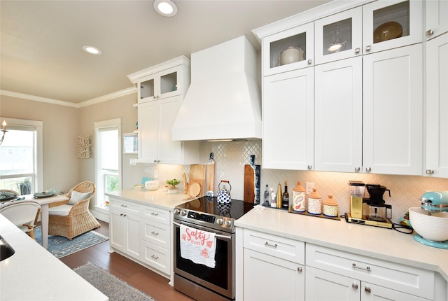 kitchen with electric range, custom exhaust hood, crown molding, and light countertops