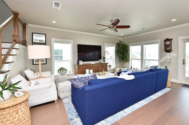 living room featuring visible vents, wood finished floors, and crown molding