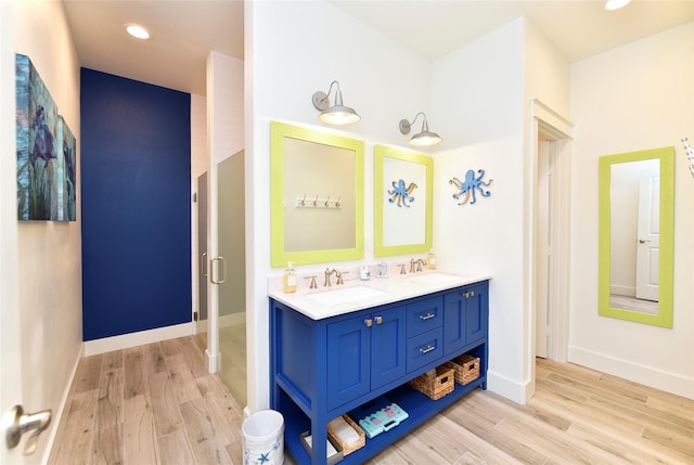 bathroom featuring wood finished floors, baseboards, and a sink