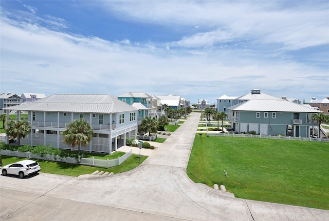 view of property's community with a residential view, a lawn, and fence