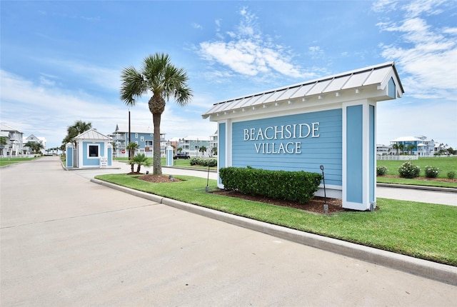 community / neighborhood sign featuring a yard and a residential view