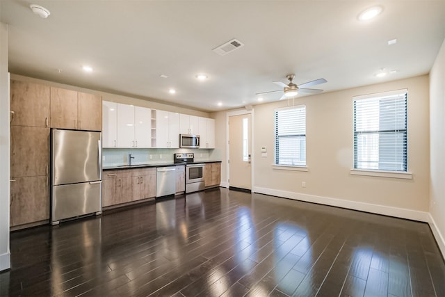 kitchen with a sink, dark wood-type flooring, visible vents, and stainless steel appliances