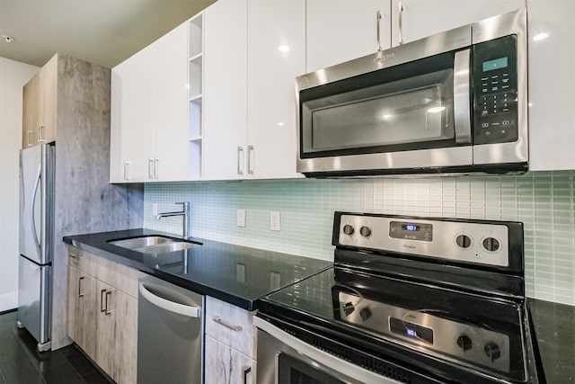 kitchen featuring decorative backsplash, appliances with stainless steel finishes, open shelves, and a sink