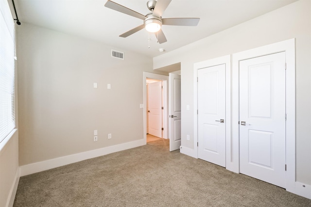 unfurnished bedroom featuring visible vents, carpet floors, baseboards, and a ceiling fan