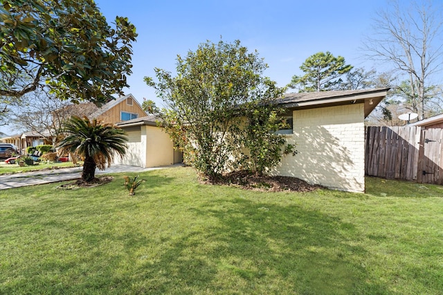 view of front of home featuring concrete driveway, a front lawn, and fence