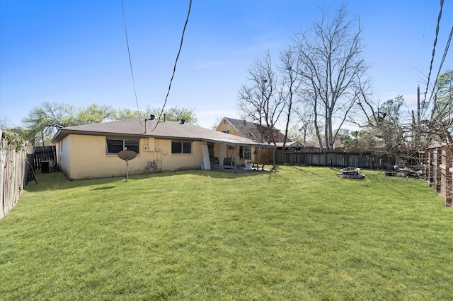 view of yard featuring a fire pit and a fenced backyard