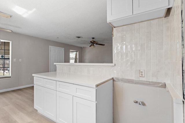 kitchen with visible vents, white cabinets, light countertops, and ceiling fan