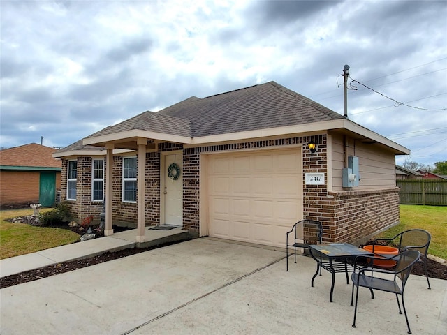 single story home with fence, a shingled roof, concrete driveway, a garage, and brick siding