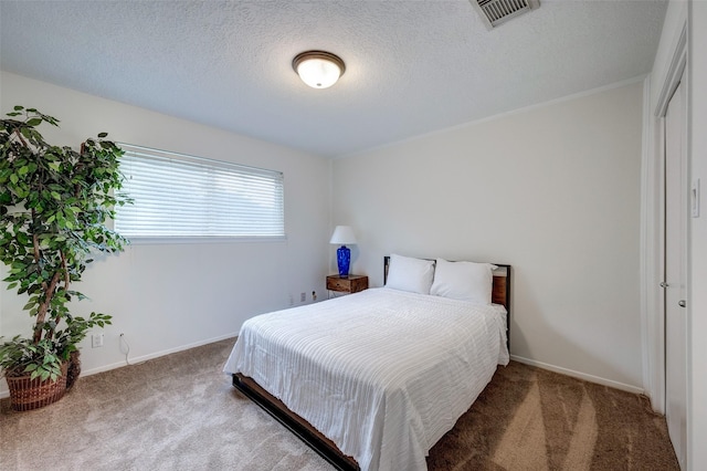 bedroom featuring baseboards, visible vents, carpet floors, and a textured ceiling