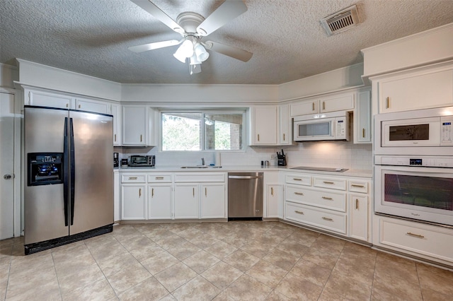 kitchen featuring visible vents, a sink, appliances with stainless steel finishes, light countertops, and decorative backsplash