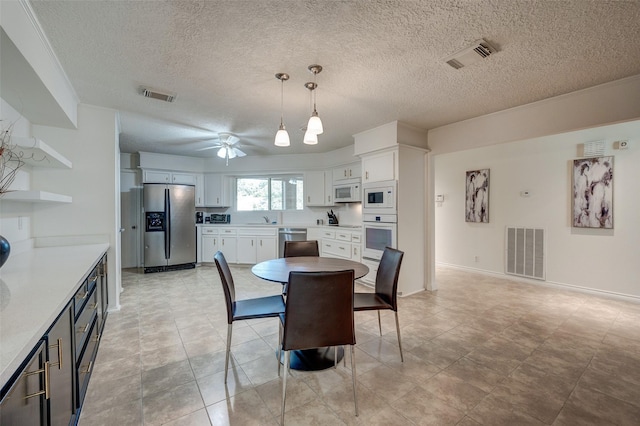 dining room with visible vents, baseboards, and ceiling fan