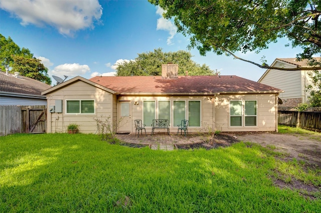 back of house featuring a patio area, a yard, a chimney, and a fenced backyard