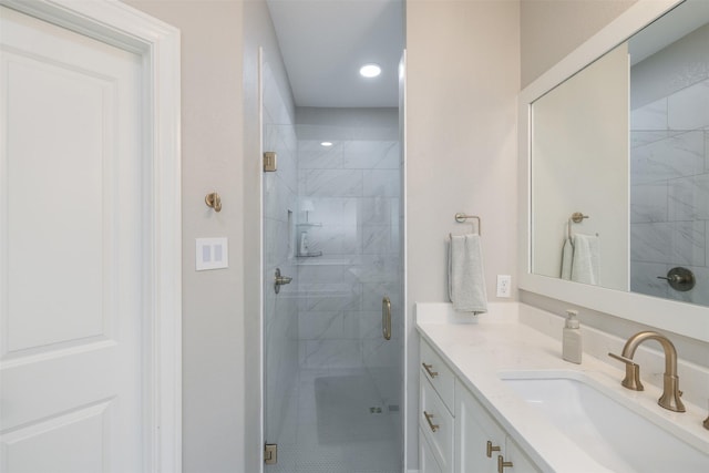 bathroom with a shower stall and vanity