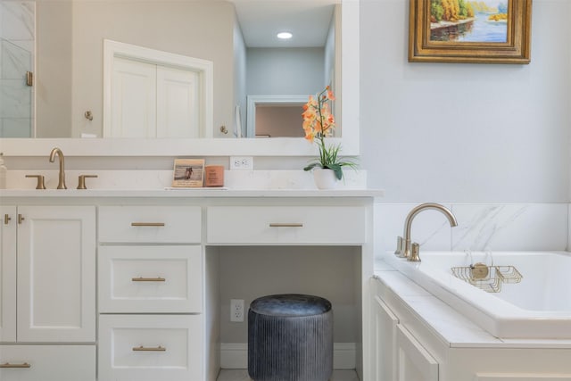 full bath featuring vanity and a tub to relax in