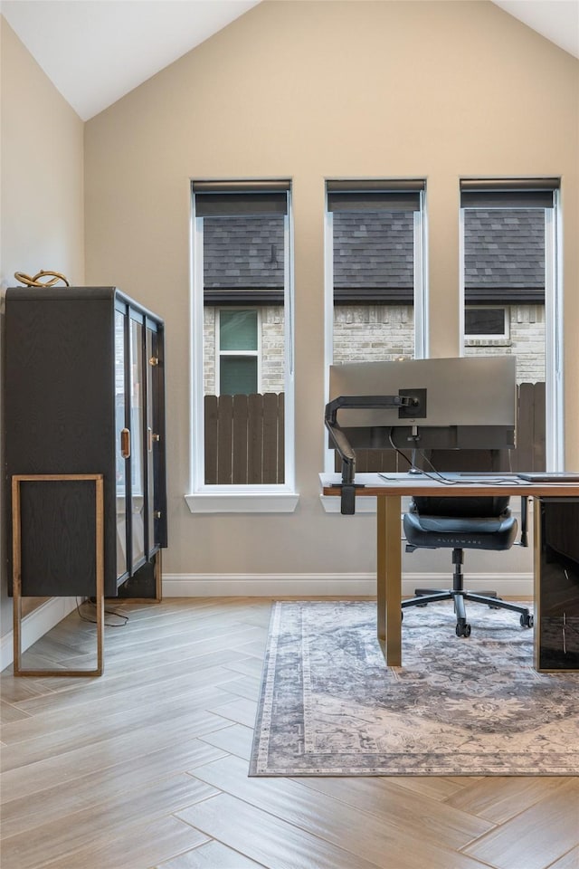 home office with lofted ceiling, wood finished floors, and baseboards