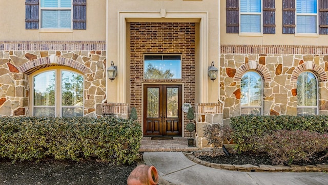 entrance to property with brick siding, stone siding, and stucco siding