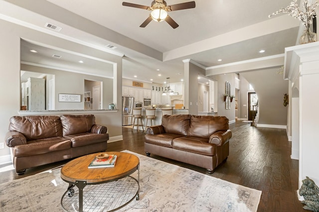 living room with visible vents, baseboards, and dark wood finished floors